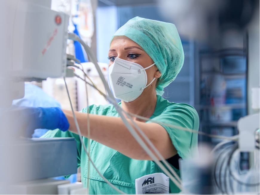 Eine Anästhesietechnische Assistentin prüft, ob alle Geräte richtig angeschlossen sind