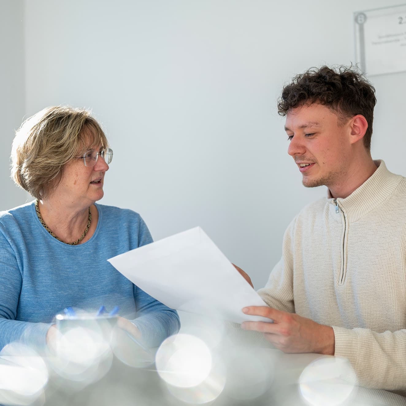 Zwei Verwaltungsmitarbeitende besprechen einen Vertrag
