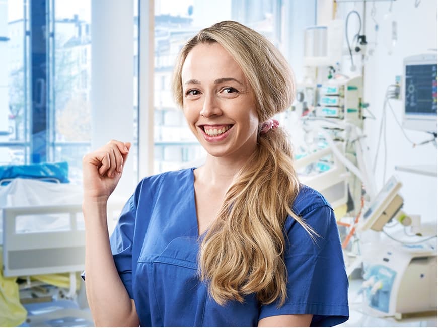 Eine Pflegefachfrau auf der Intensivstation blickt in die Kamera