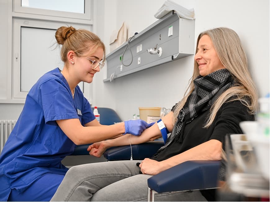 Eine Auszubildende zur Medizinischen Fachangestellten nimmt Blut ab