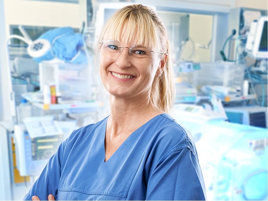 Eine Pflegefachfrau auf der Neonatologie blickt in die Kamera