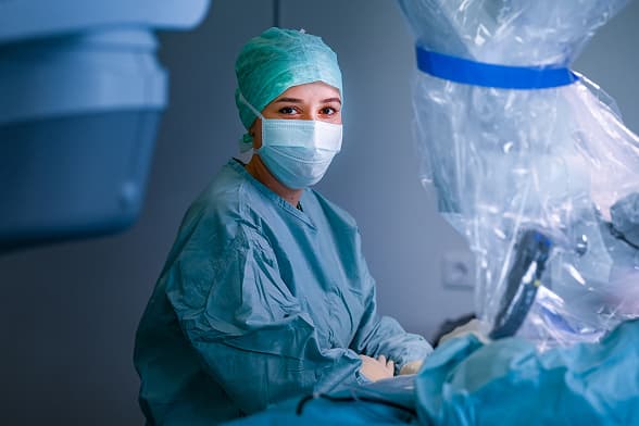 Eine Operationstechnische Assistentin blick während einer OP in die Kamera