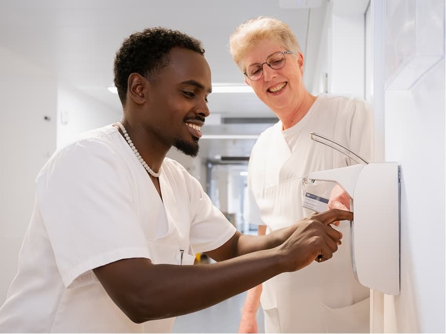 Ein Auszubildender zum Pflegefachhelfer lernt die hygienische Händedesinfektion