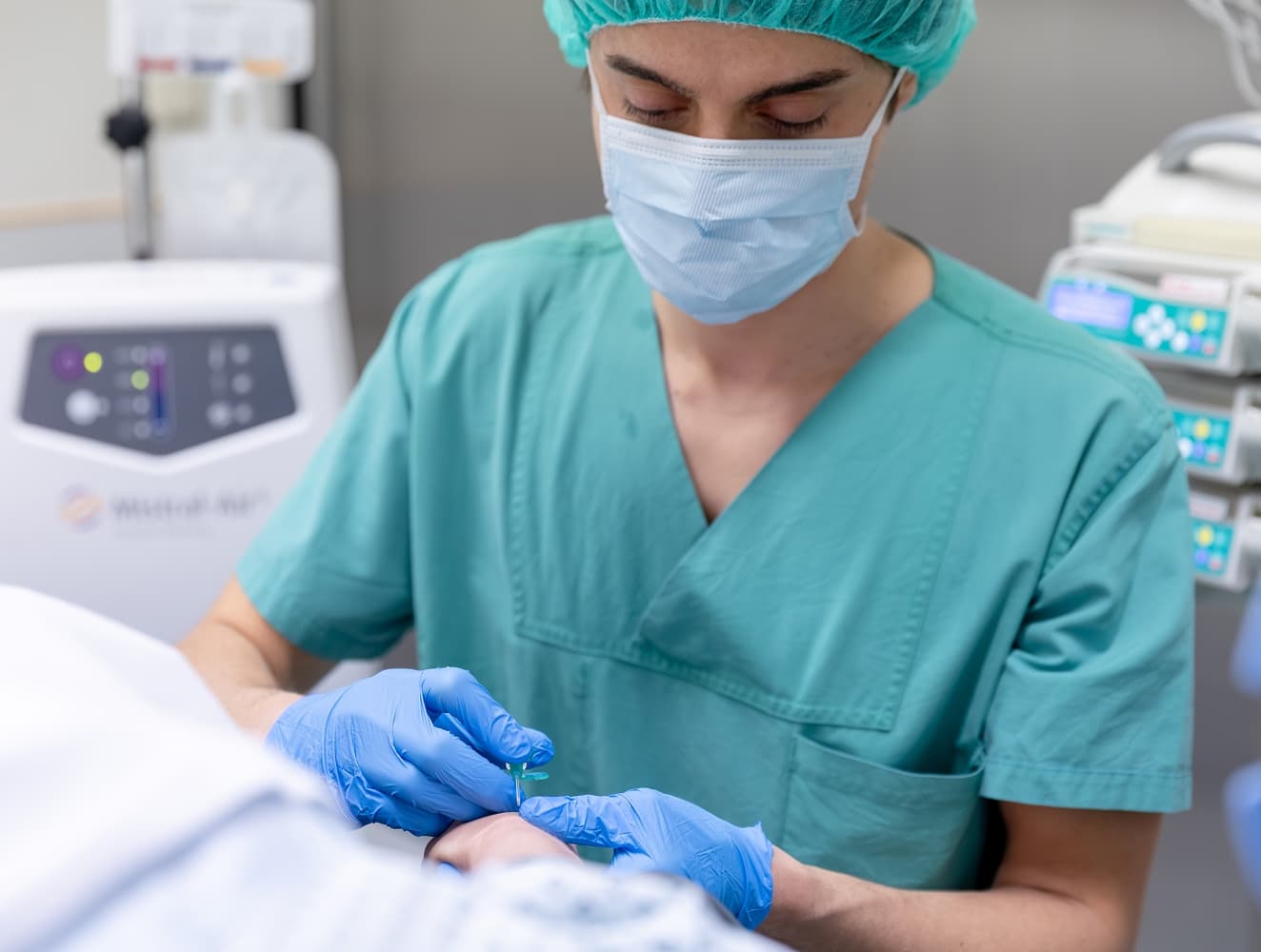 Ein Anästhesietechnischer Assisten legt behutsam einer Patienten einen Zugang