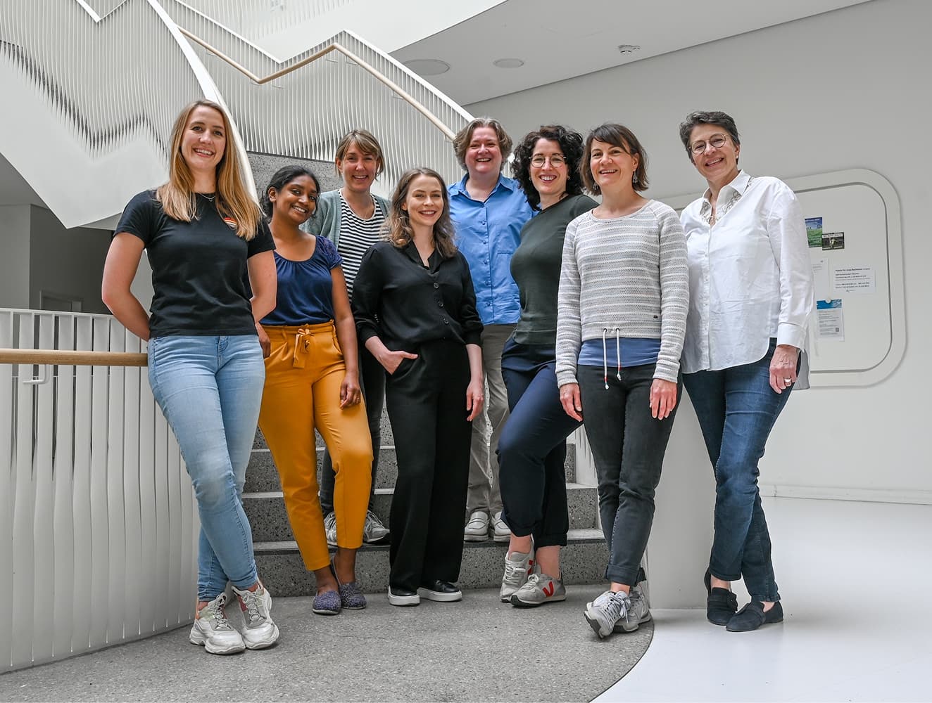 Das Team der Pflegewissenschaftlerinnen steht im Treppenhaus, alle blicken in die Kamera