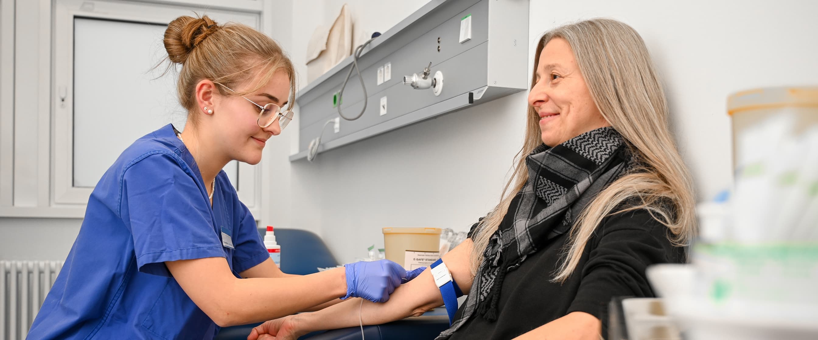 Eine Auszubildende zur Medizinischen Fachangestellten nimmt Blut ab